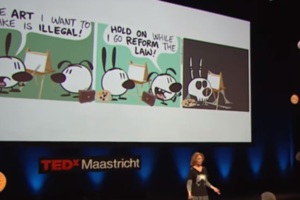 A photo of cartoon artist Nina Paley speaking at TedX Maastricht about her take on copyright law. This image is attached to a post titled "Should we just abolish copyright law?"