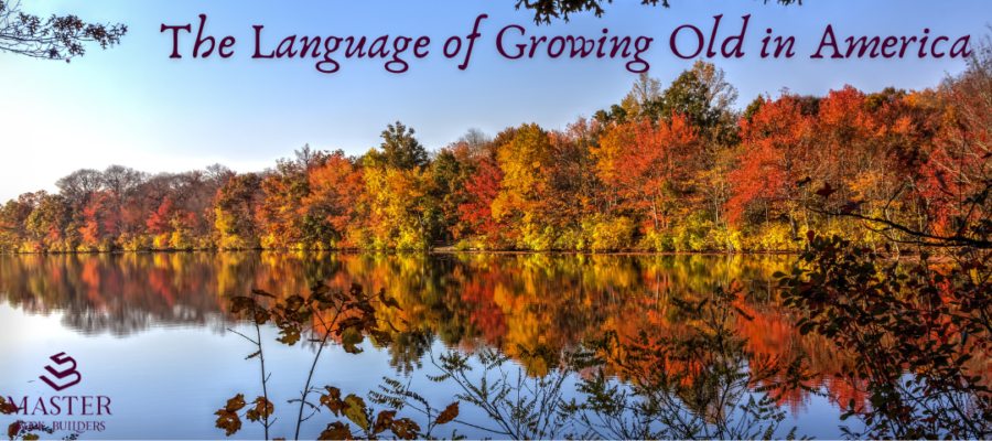 Trees along the edge of a lake radiant with autumn colors. The trees are reflected in the water of the lake. Text on the image reads "The language of growing old in America."