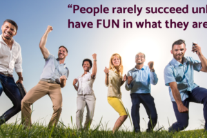 A group of people in a field making "victory" gestures such as a fist pump. Over the image is a quote from Dale Carnegie that reads, "People rarely succeed unless they have fun in what they are doing." The image is attached to a post on how to build fun into your brand statement.
